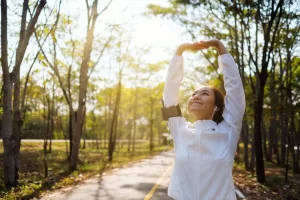 Uma mulher asiática esticando os braços antes de correr no parque da cidade