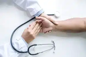 Médico segurando as mãos de um paciente